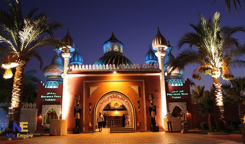 Illuminated Pharaonic Show venue entrance with ornate domes and palm trees at night