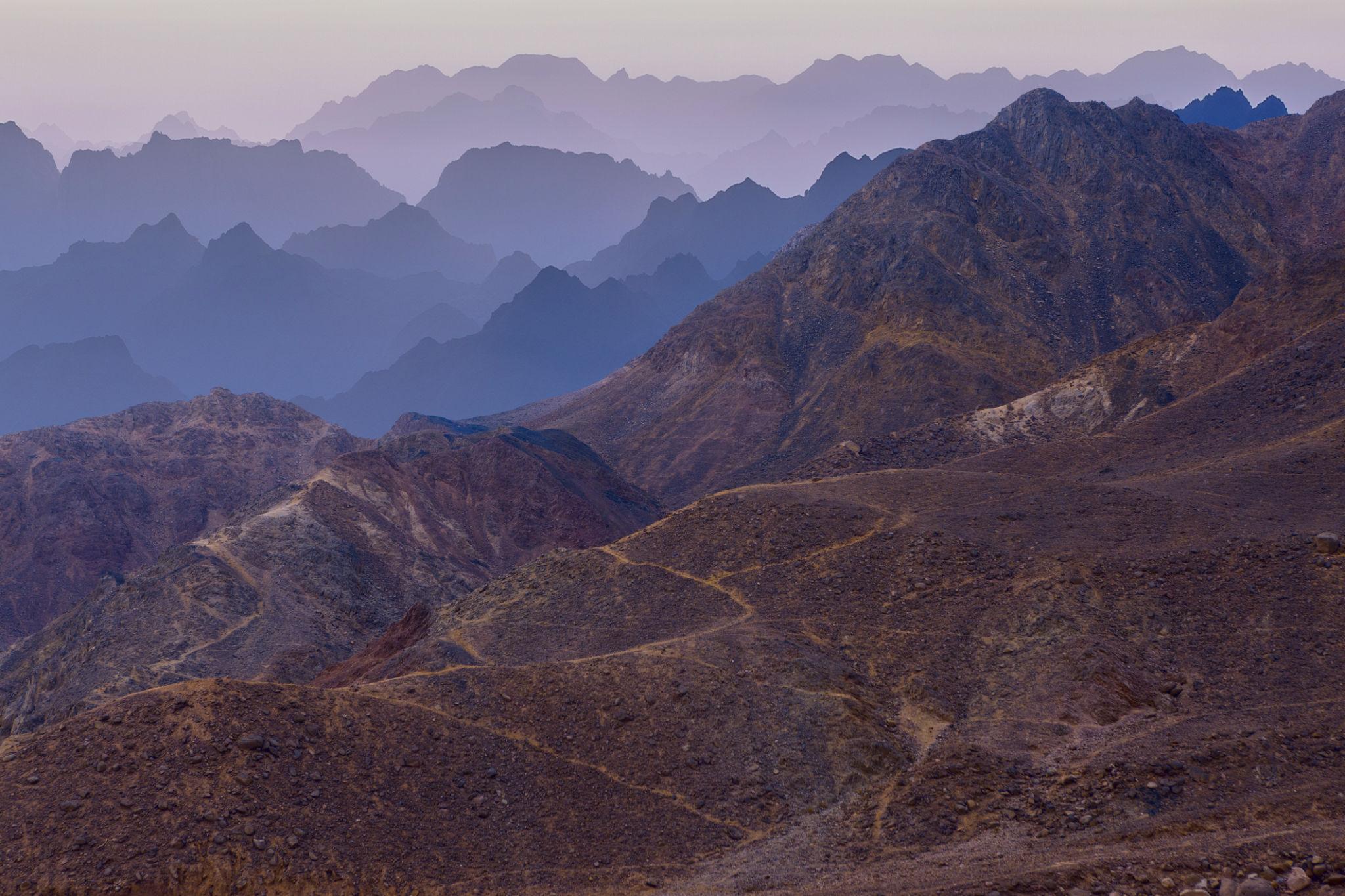 Layered rocky mountain ridges fading into blue haze above the Red Sea coast