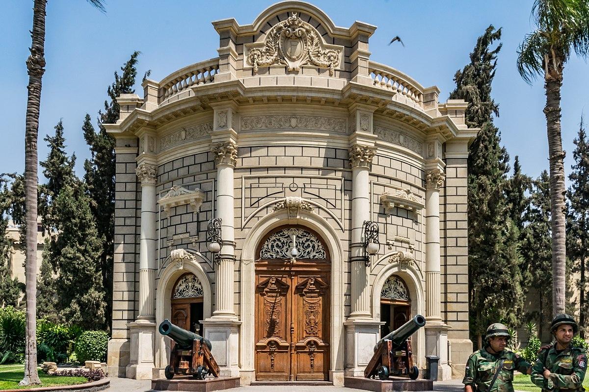Ornate neoclassical entrance of NMEC with two cannons and soldiers standing guard