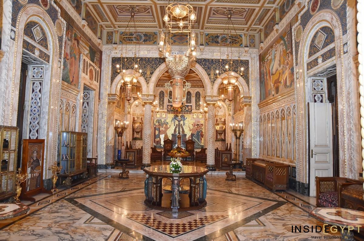 Ornate palace reception hall with painted arches, chandelier and marble floor