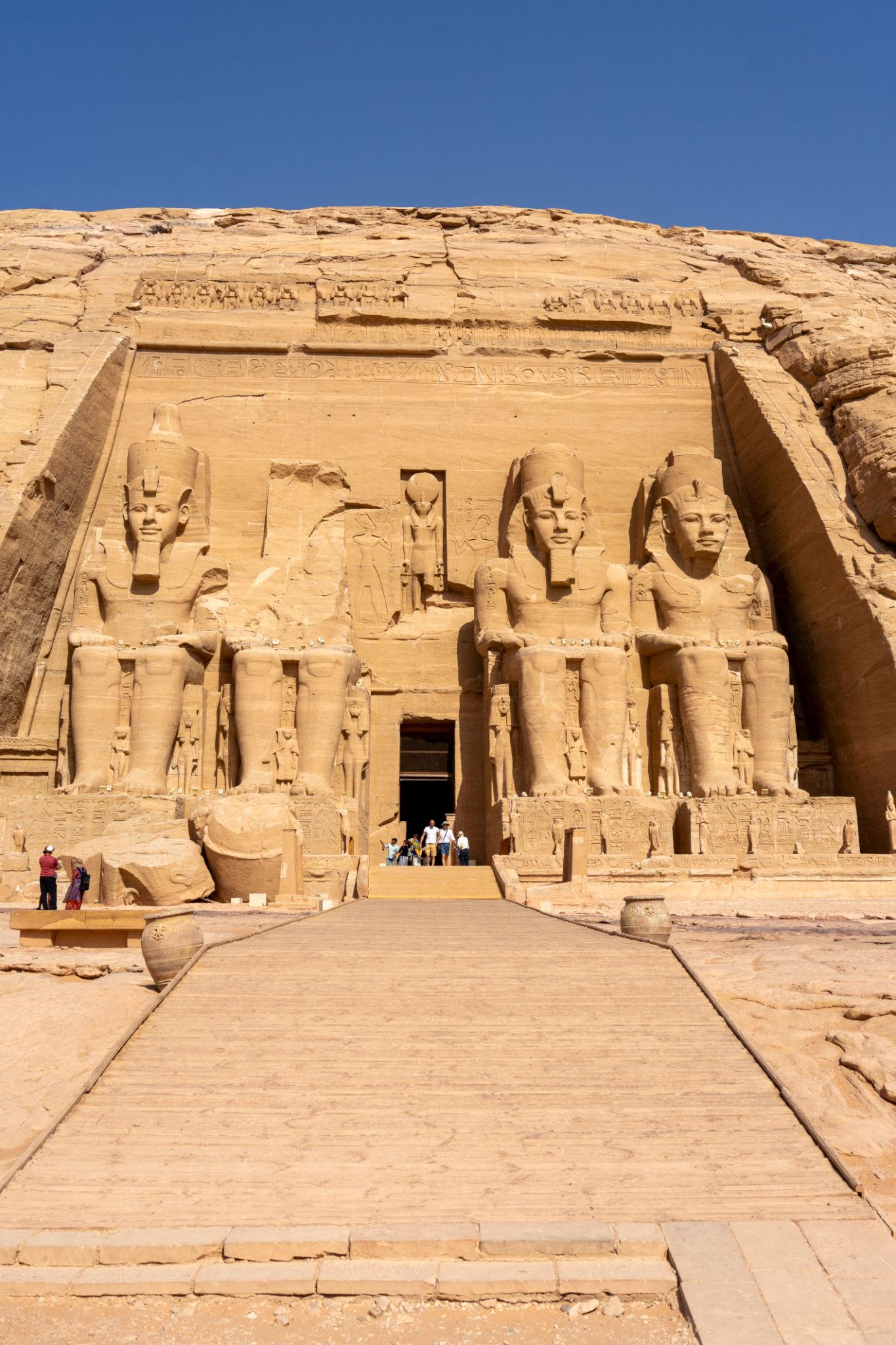 Four giant colossi of Ramesses II flank the entrance to Abu Simbel temple carved into sandstone cliff