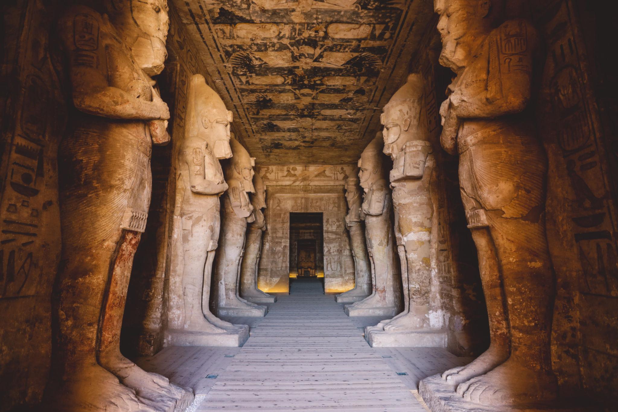 Massive Osiride statues of Ramesses II lining the decorated hypostyle hall inside Abu Simbel temple
