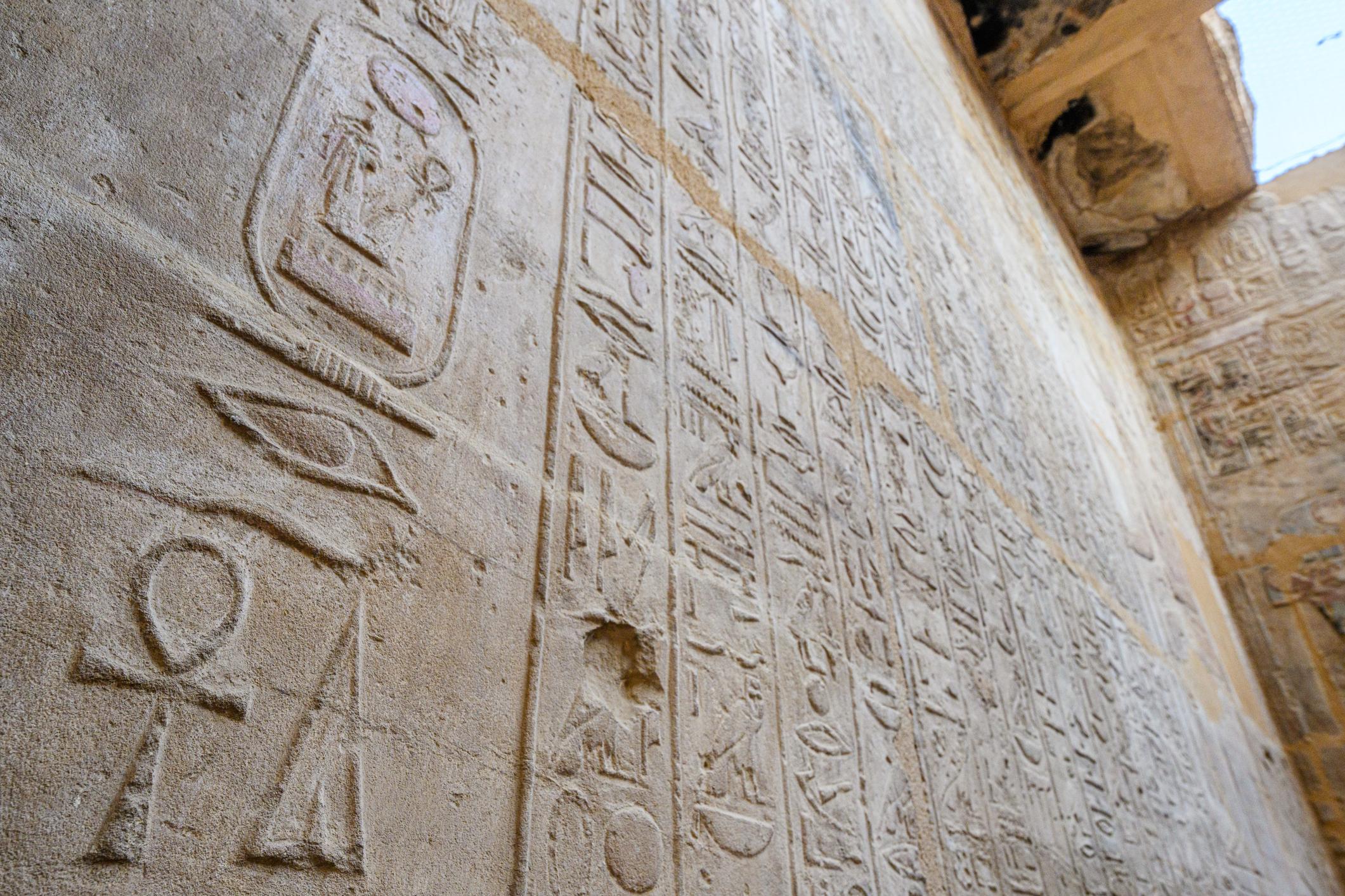 Wall covered with dense hieroglyphic columns inside the Temple of Seti I.