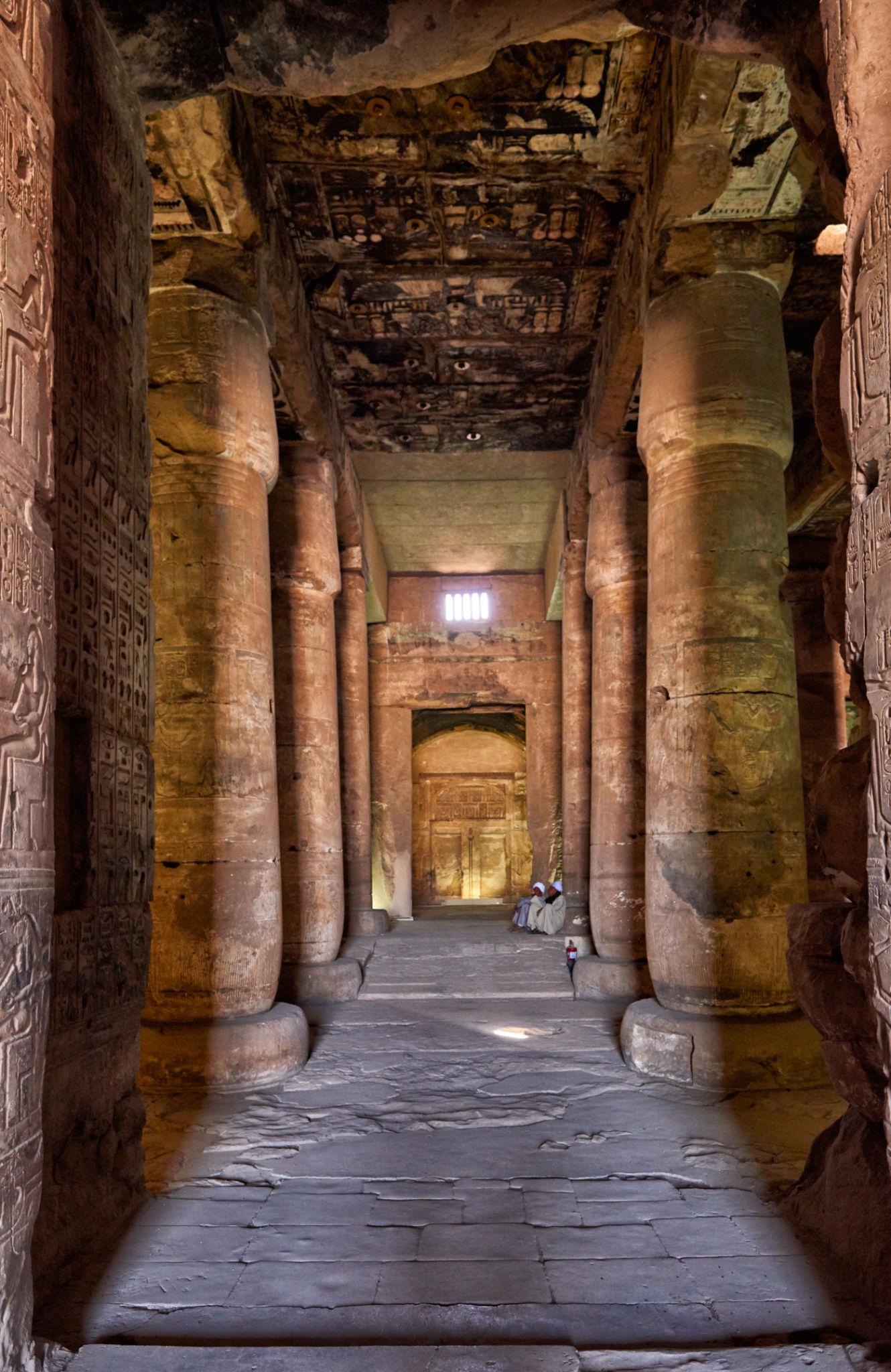 Corridor of towering columns beneath a painted ceiling at the Temple of Seti I.