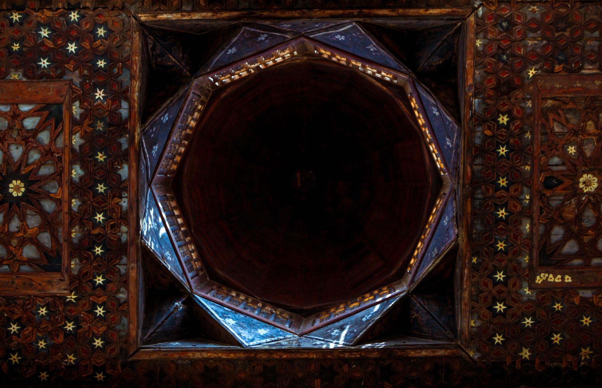 Ornate octagonal wooden dome ceiling with geometric star patterns at NMEC