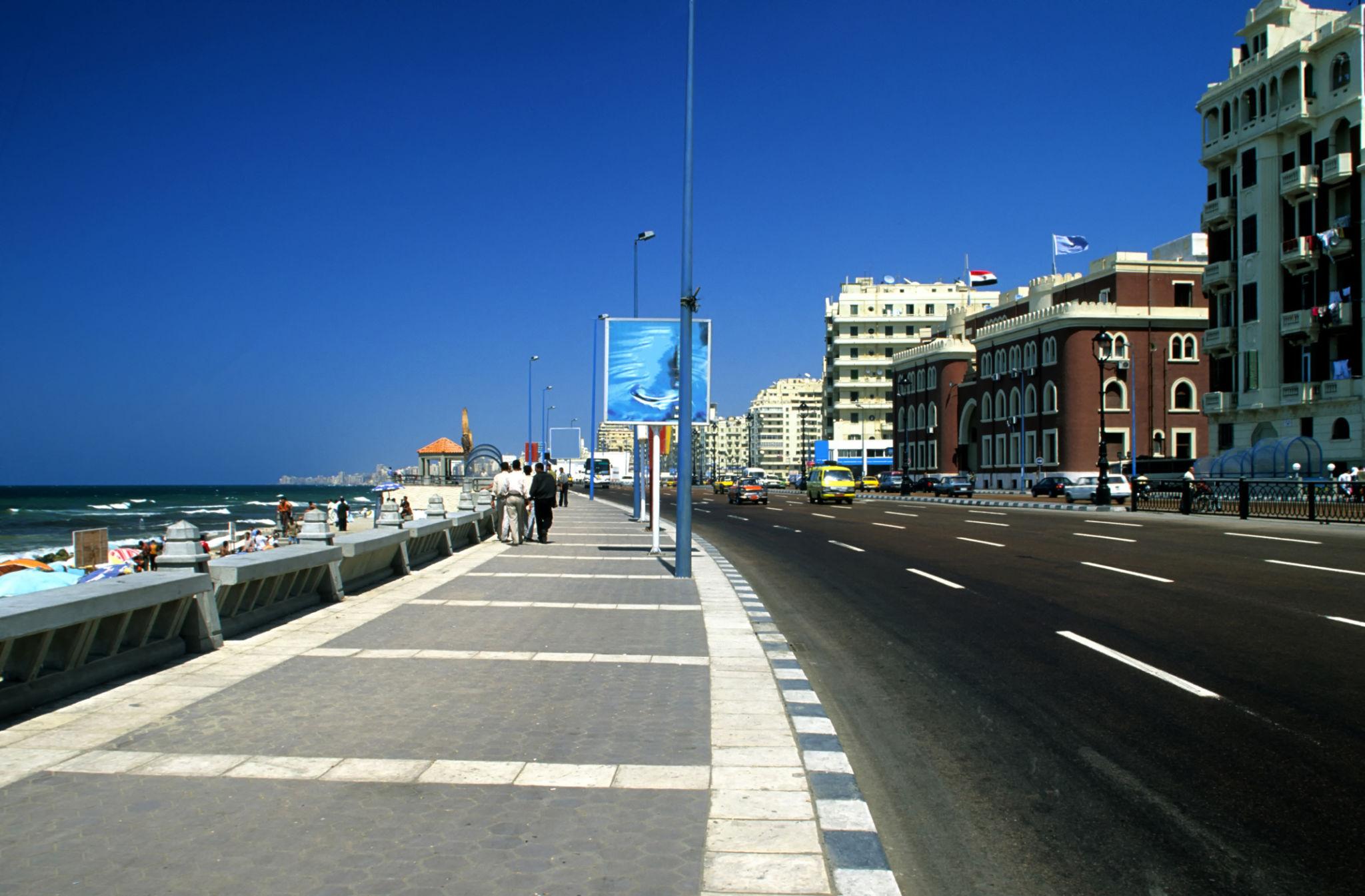 Wide Corniche boulevard and pedestrian promenade beside the Mediterranean with colonial-era buildings