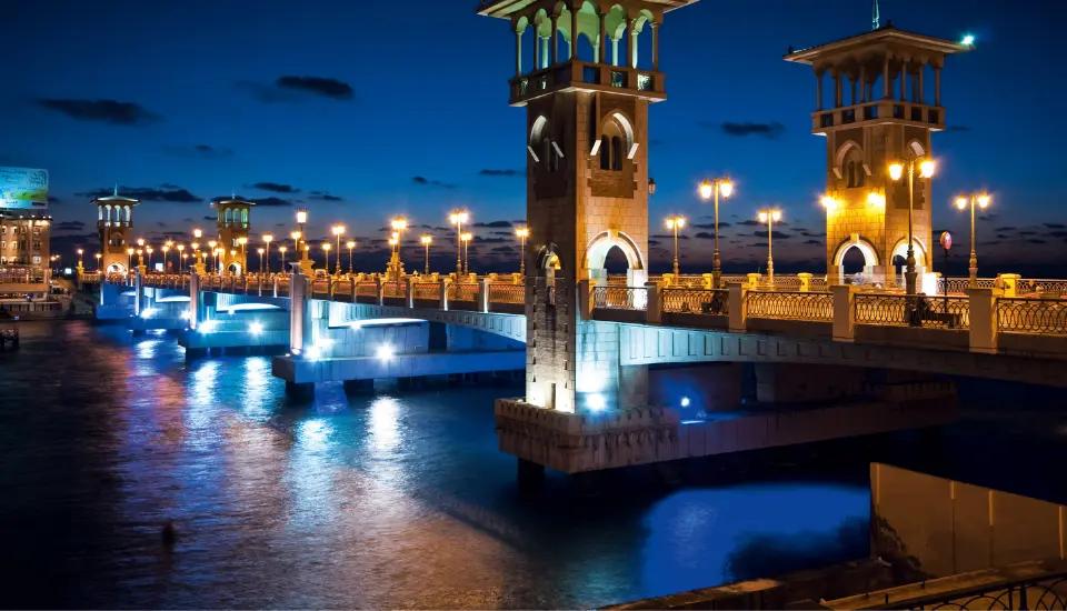 Stanley Bridge towers illuminated at night above the Mediterranean along the Alexandria Corniche