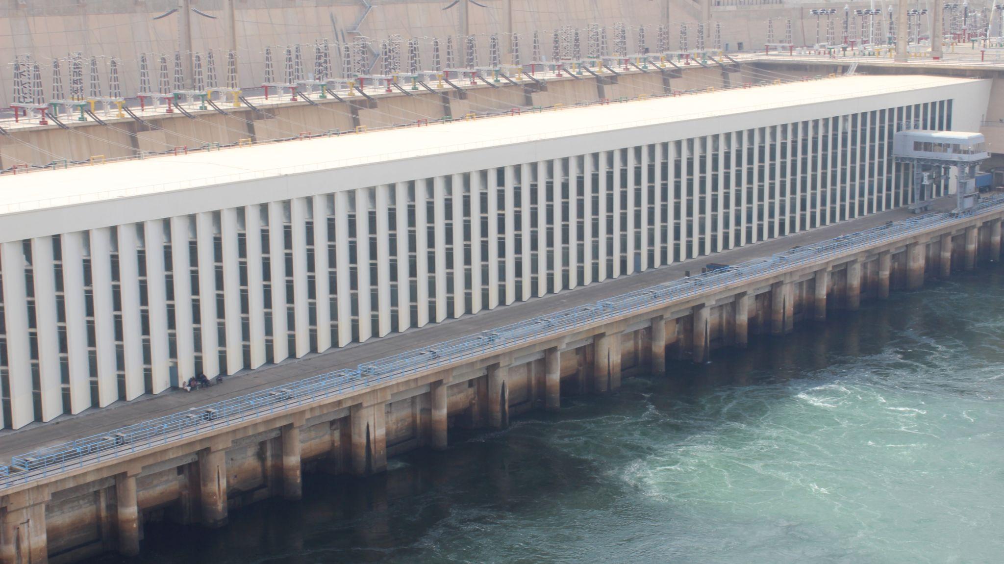Long white turbine hall facade of Aswan High Dam along the Nile River