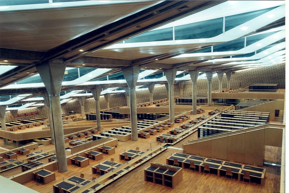 Cascading terraces of reading desks beneath the Bibliotheca Alexandrina's slanted glass roof