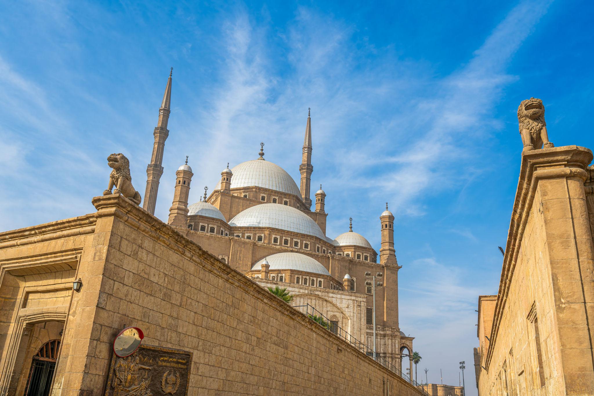 Domes and twin minarets of the Muhammad Ali Mosque rising above the Citadel walls and lion statues