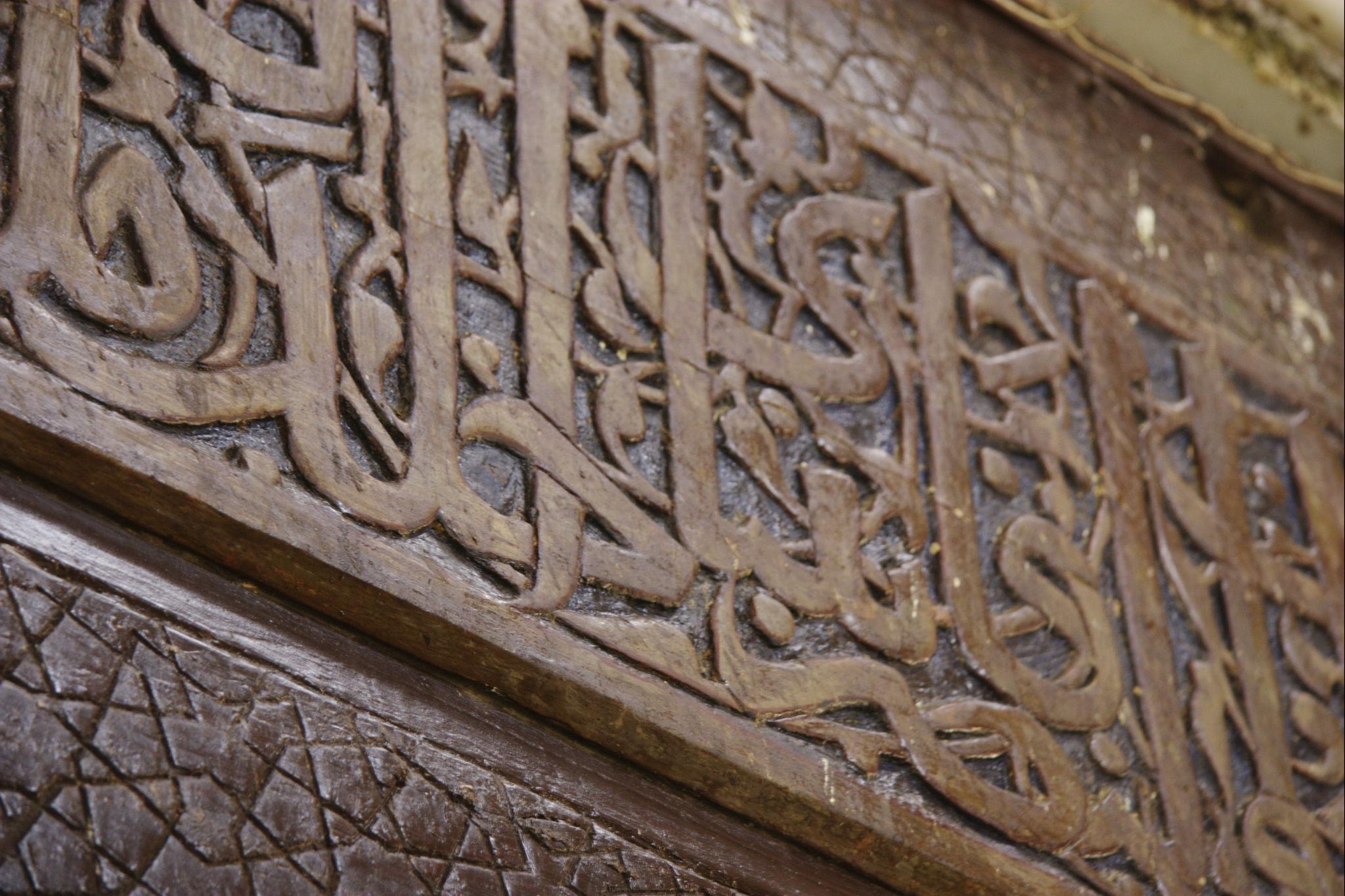 Close-up of carved Arabic calligraphy band on a Mamluk tomb wall in the City of the Dead