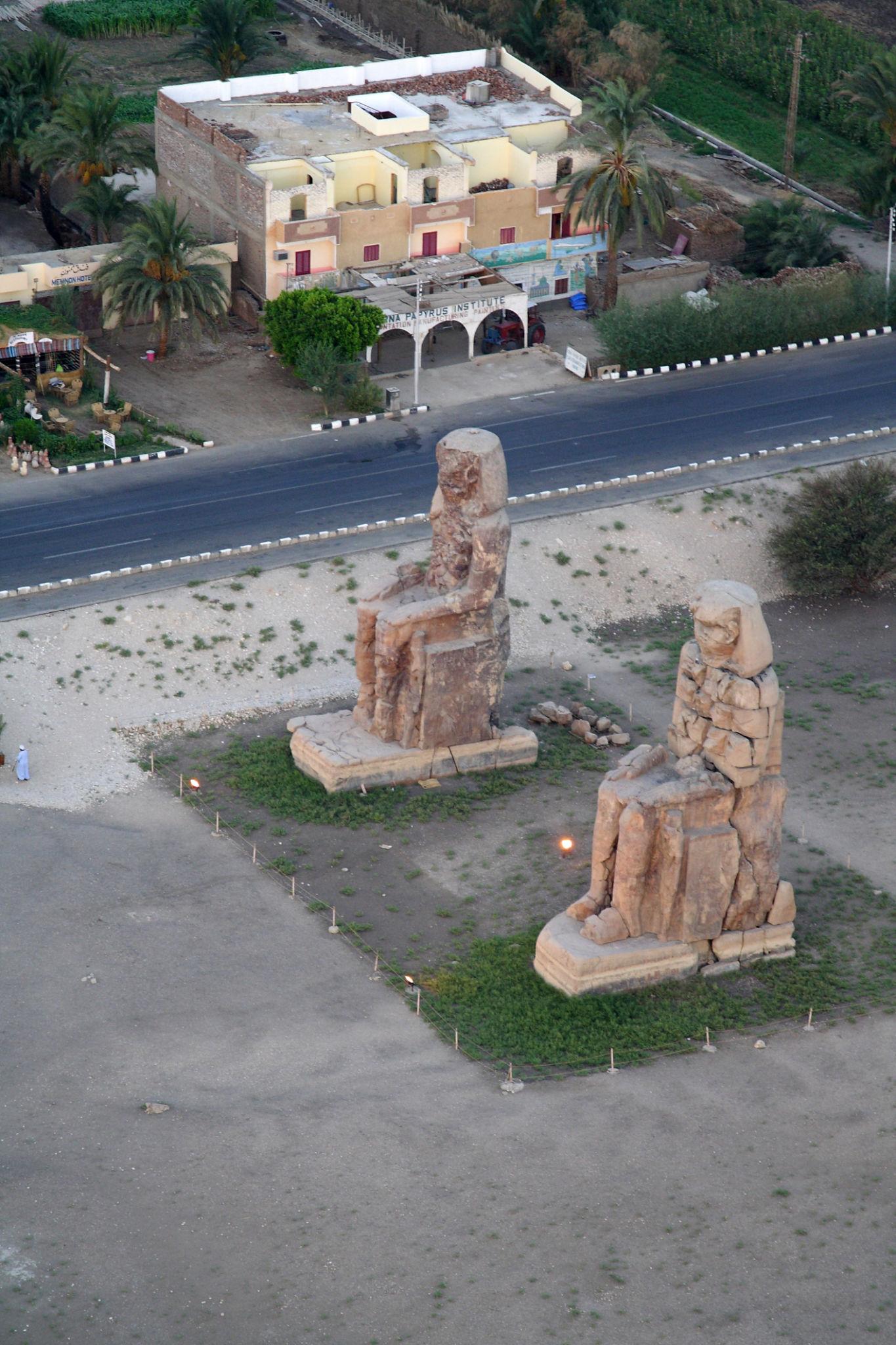 Aerial view of the Colossi of Memnon seen from above beside a road in Luxor
