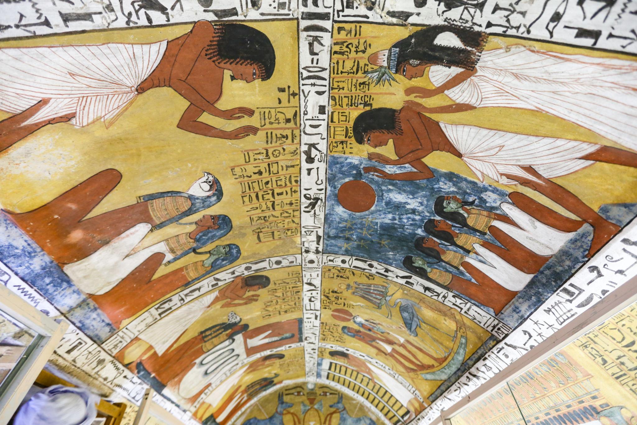 Painted ceiling of Deir el-Medina tomb showing celestial goddesses embracing the deceased among hieroglyphs