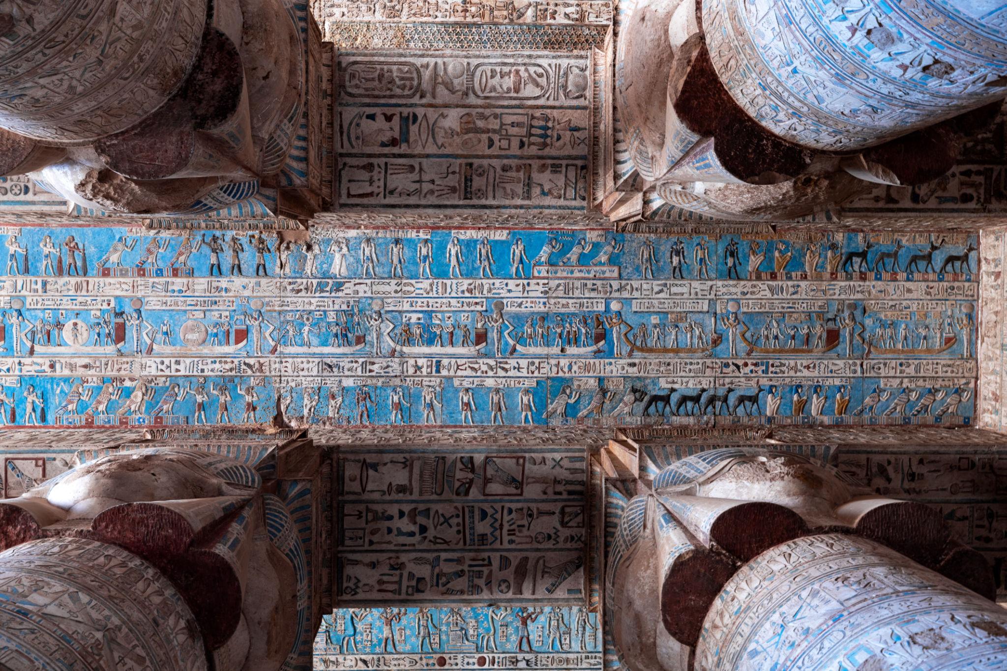 Panoramic view of Dendera's restored blue astronomical ceiling between column capitals.