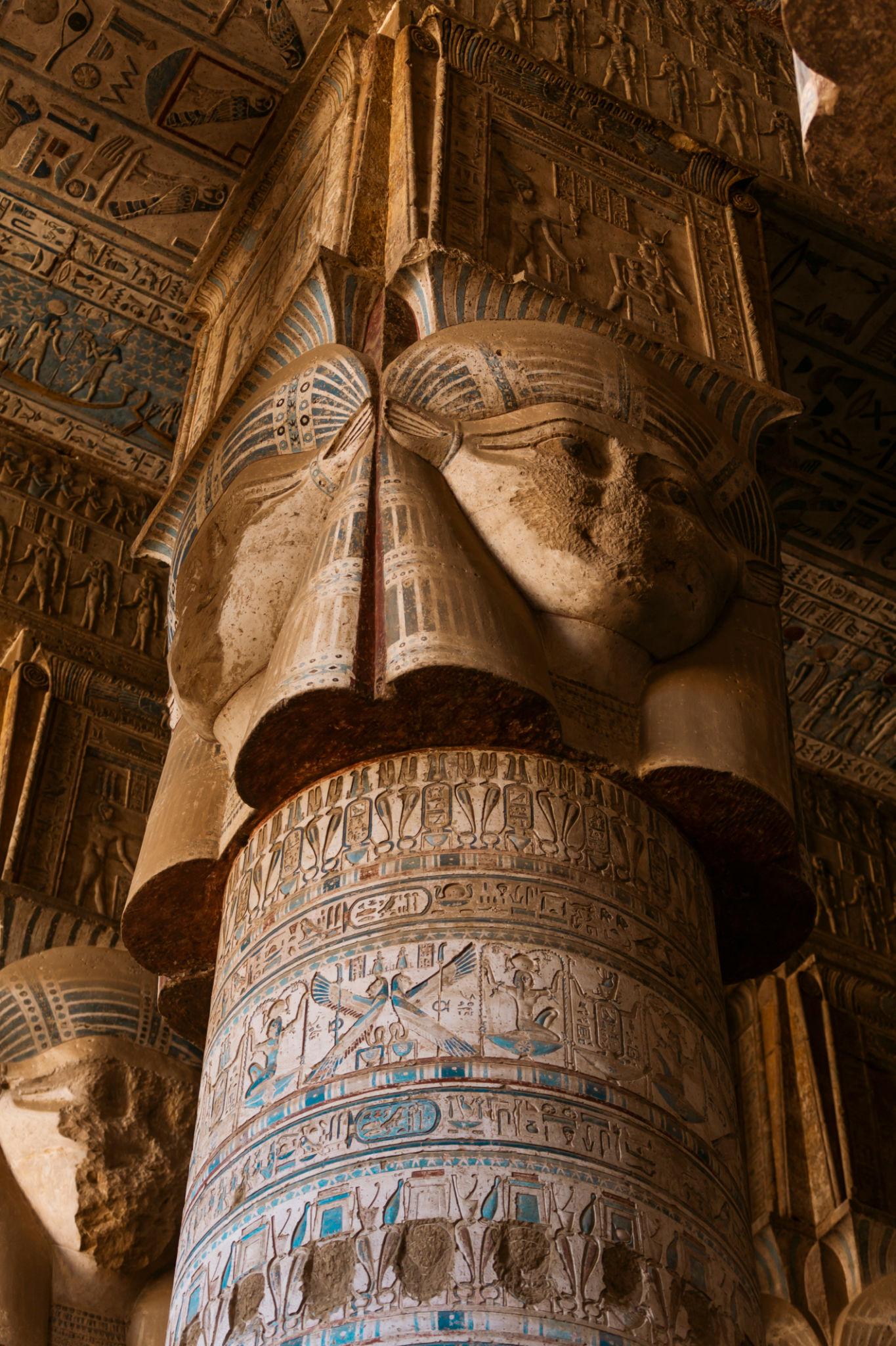 Close-up of a four-faced Hathor capital crowning a carved column at Dendera.