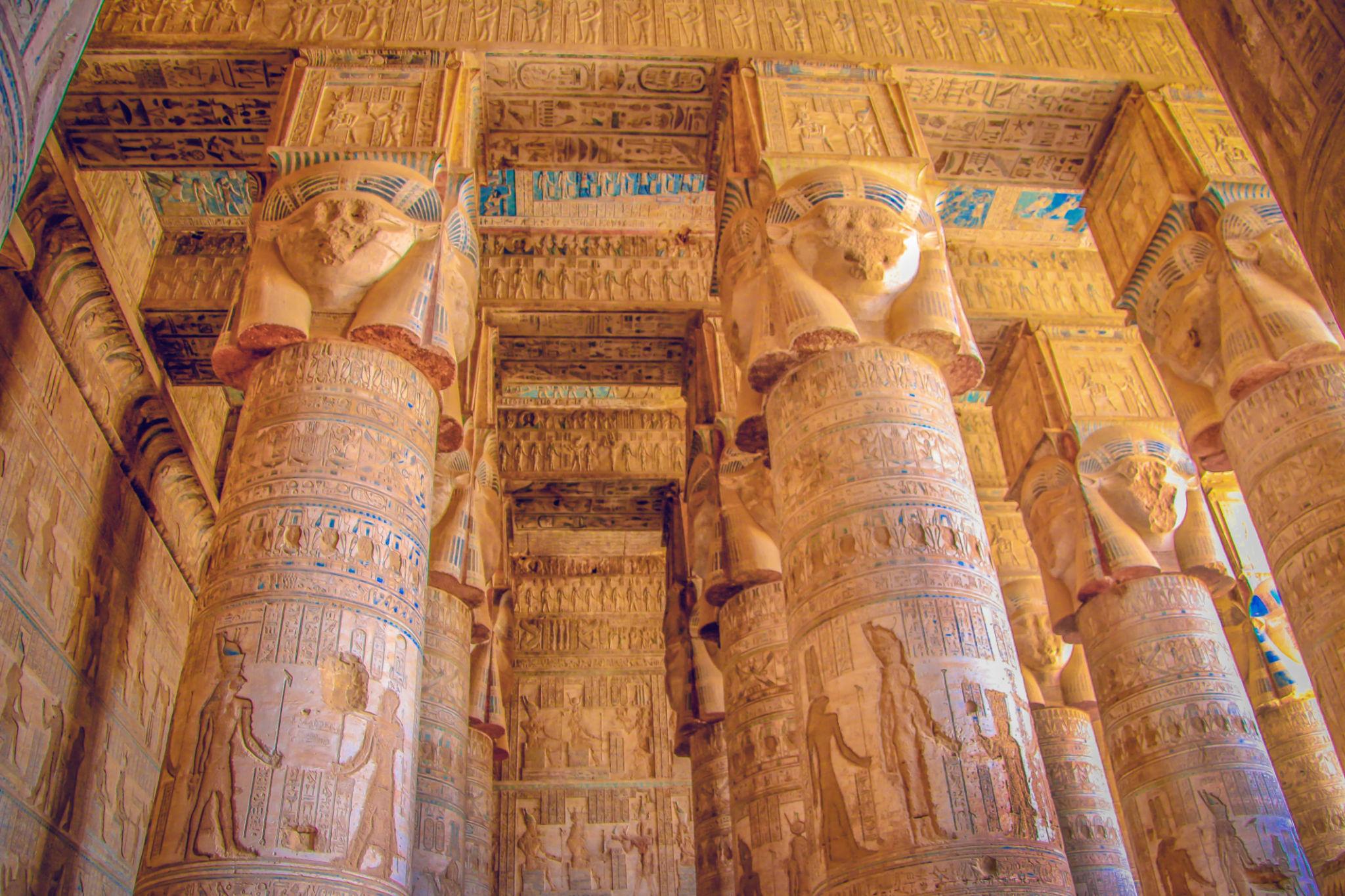 Golden Hathor-capital columns and painted ceiling of Dendera's hypostyle hall.