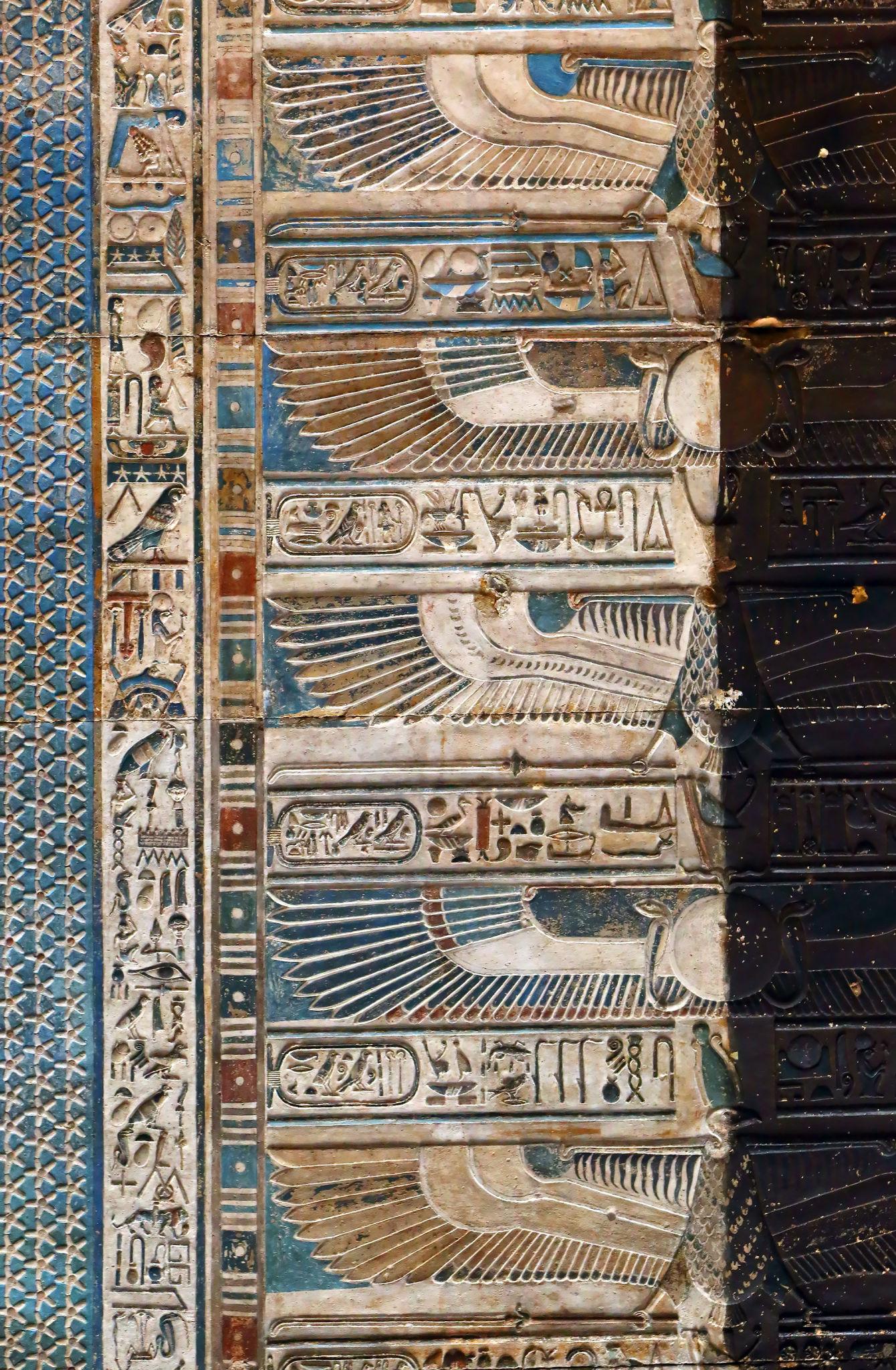 Winged vulture-goddess frieze running along a painted wall at Dendera Temple.