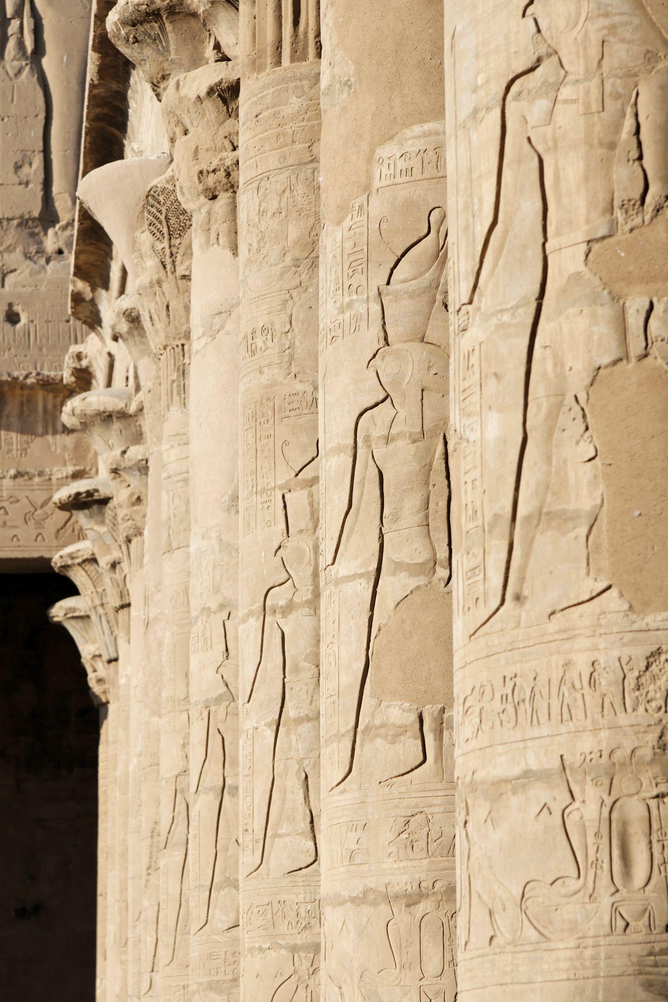 Closeup of deity reliefs carved onto colonnade columns at the Temple of Edfu.