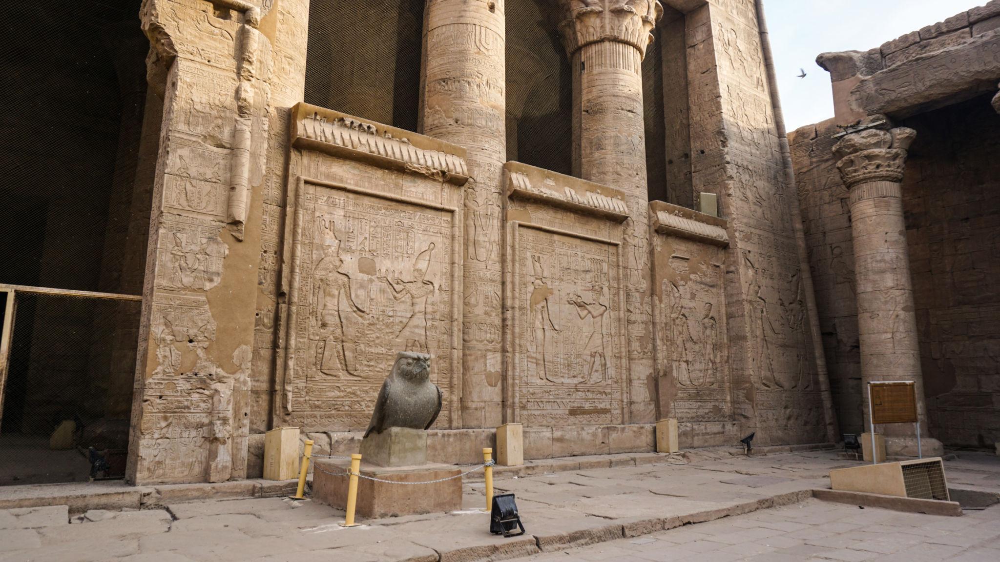 Granite Horus falcon statue guarding the pronaos entrance at the Temple of Edfu.