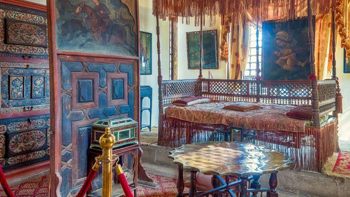 Ottoman bedroom with carved wooden bed, painted cabinets and antique furnishings at Gayer-Anderson Museum