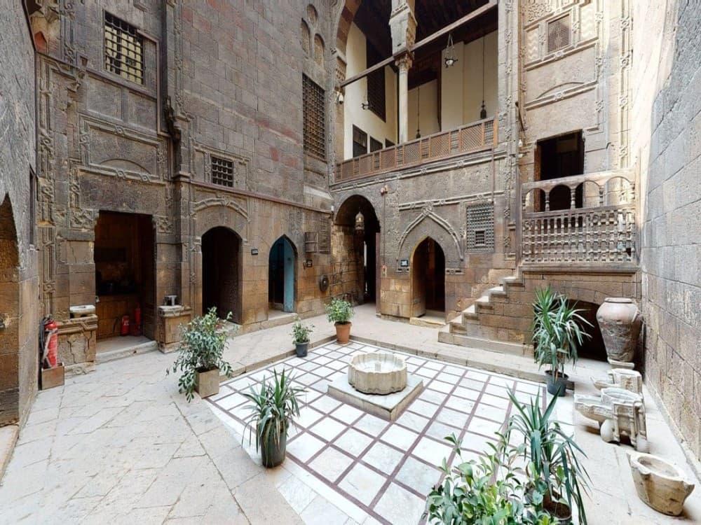 Stone courtyard with arched doorways and carved facades inside the Ottoman-era Gayer-Anderson Museum