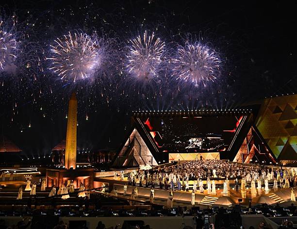 Spectacular fireworks illuminate a grand outdoor ceremony at NMEC with Egyptian-themed stage.