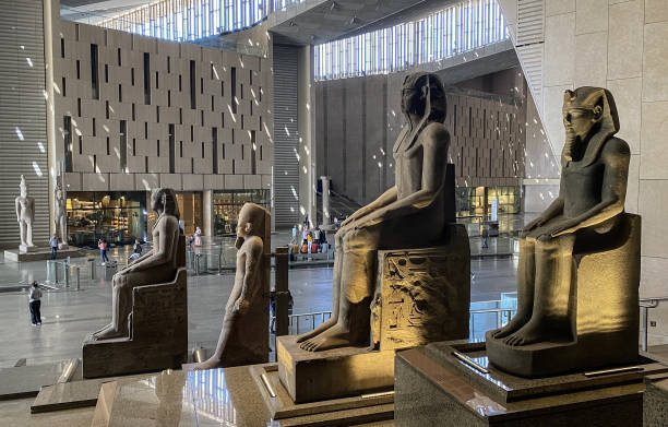 Large ancient Egyptian pharaoh statues displayed in the grand atrium of the NMEC