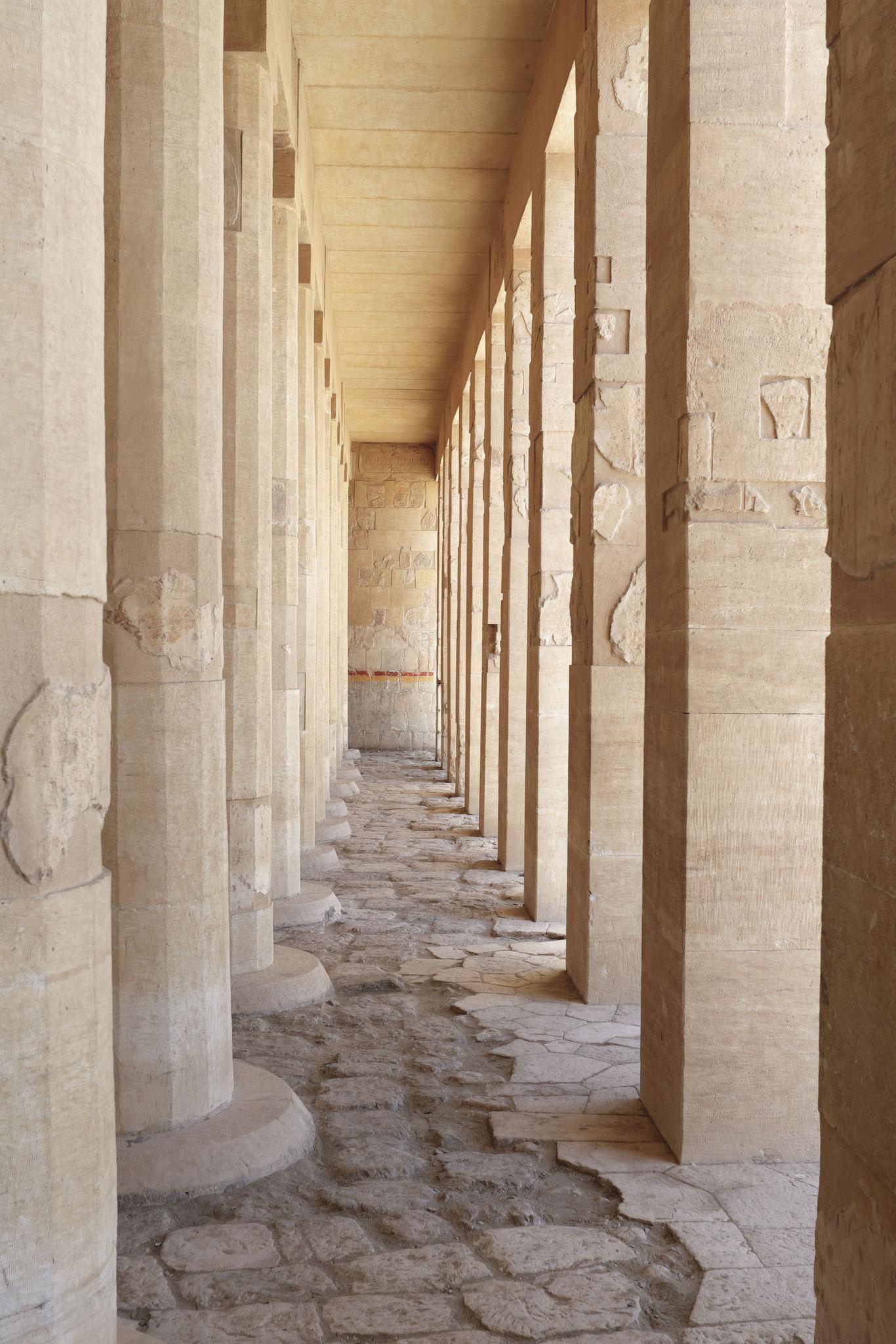 Perspective view down a row of square sandstone pillars inside Hatshepsut Temple