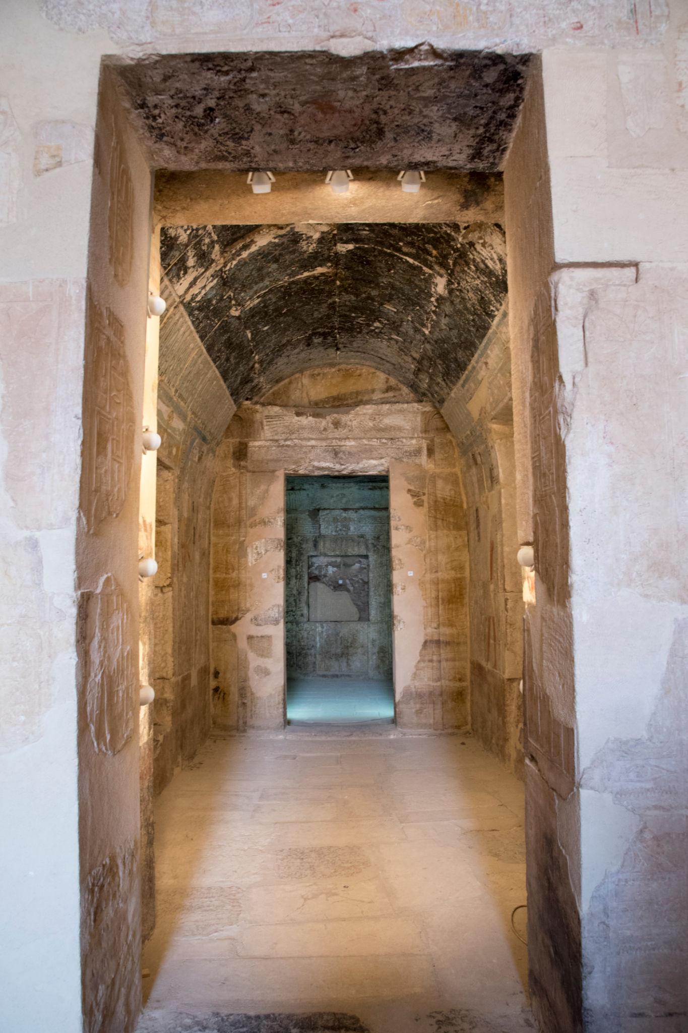 Vaulted stone corridor leading through sanctuary doorways inside Hatshepsut Temple
