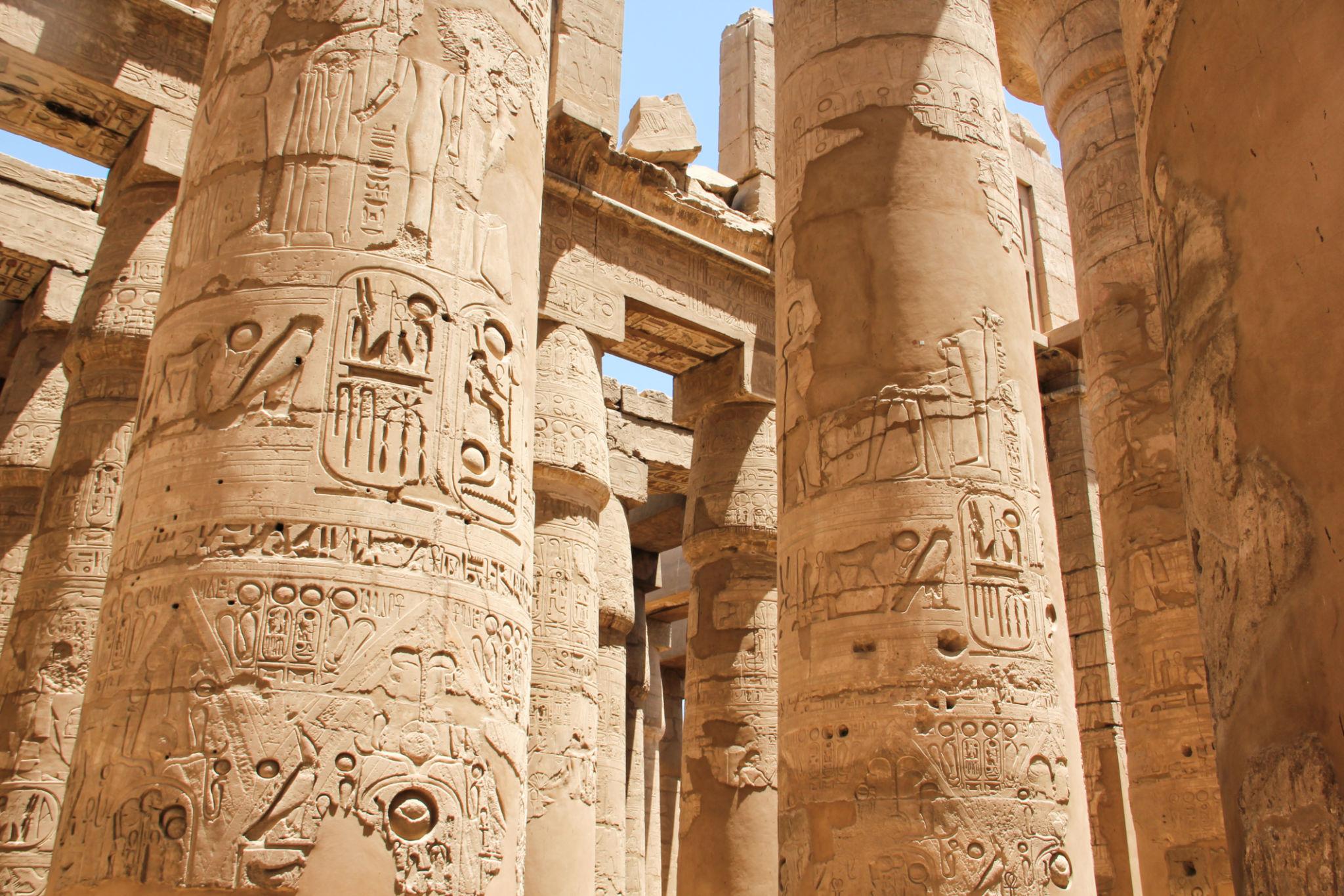 Sunlit columns carved with hieroglyphs inside Karnak's Great Hypostyle Hall