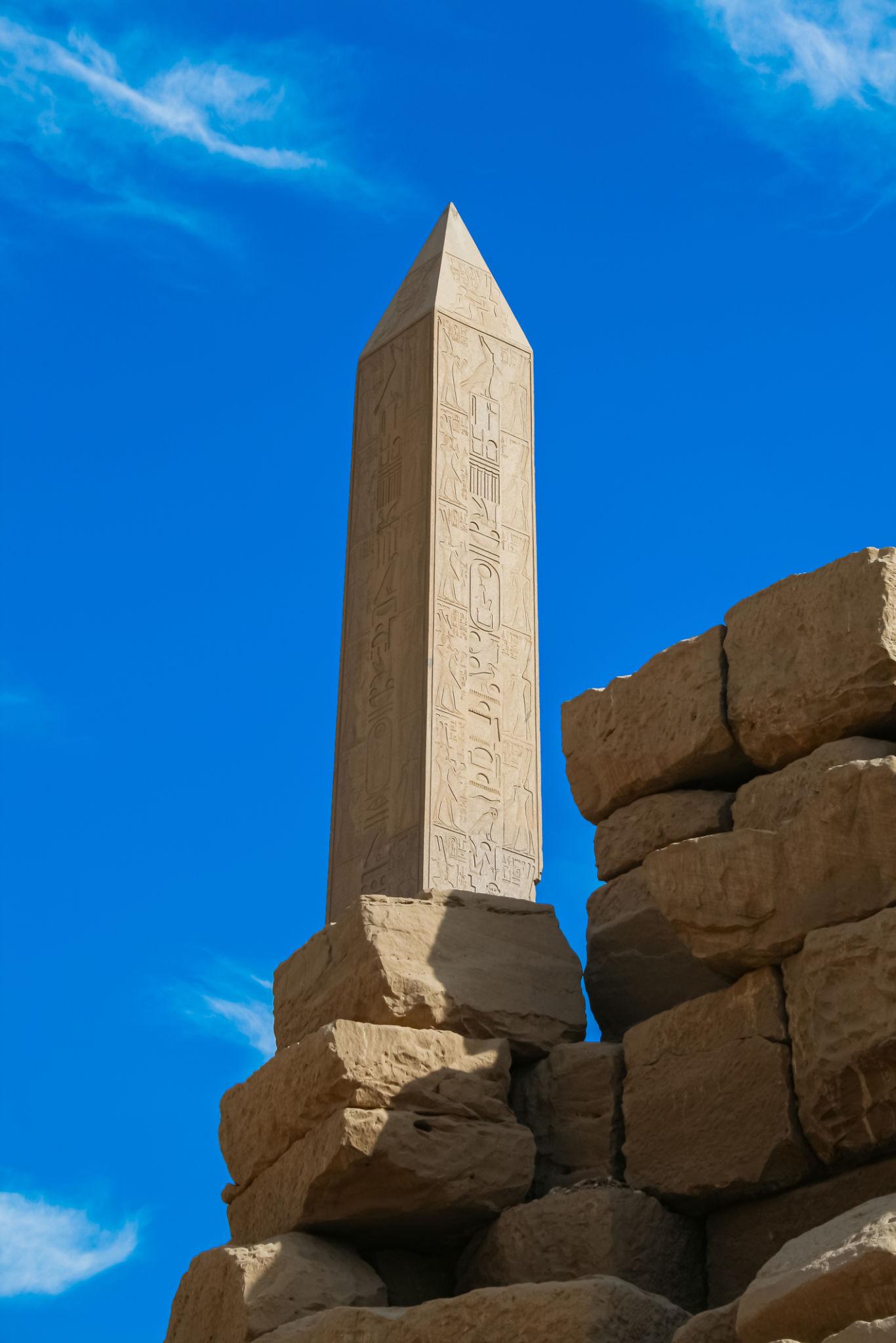 Hatshepsut's towering granite obelisk rising against a bright blue sky