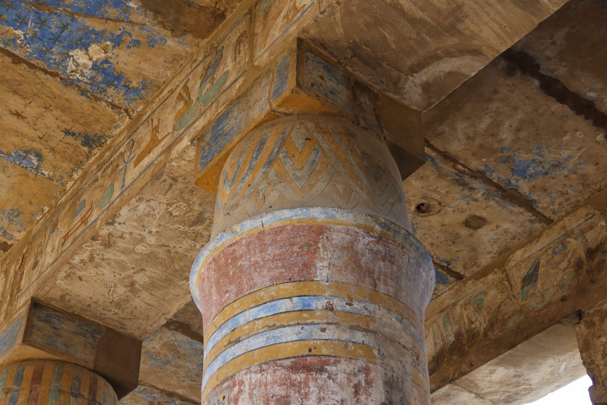 Close-up of an ancient painted column capital with blue and red pigment