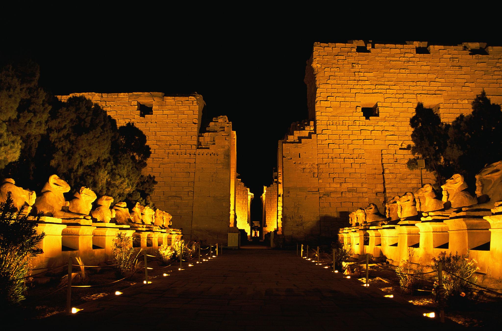 Illuminated avenue of sphinxes leading to Karnak Temple's first pylon at night