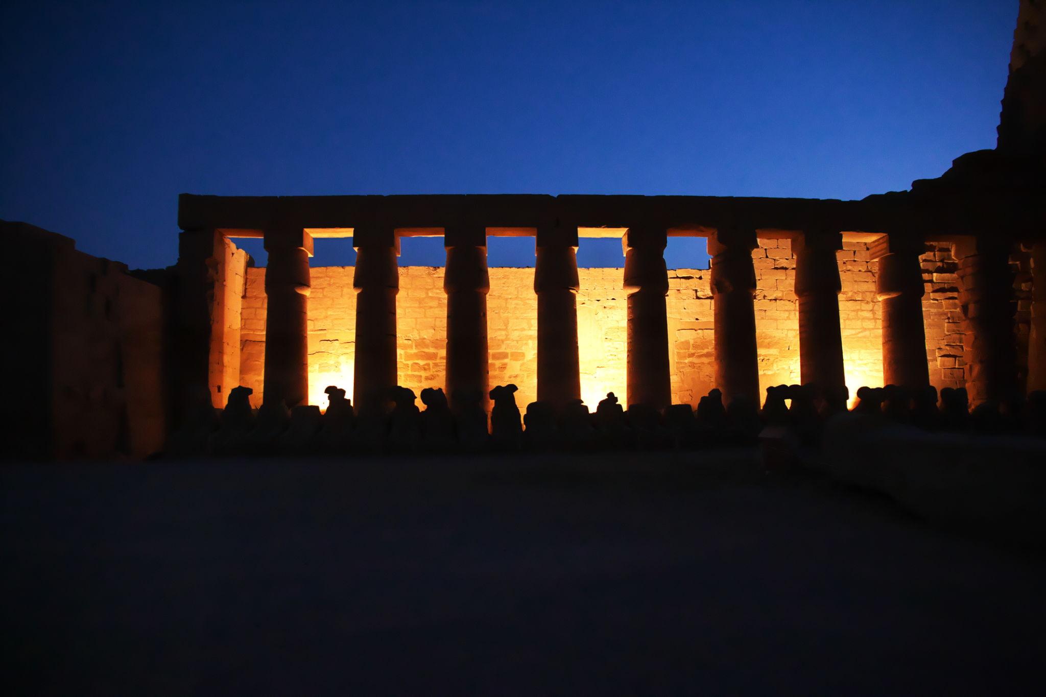 Karnak Temple colonnade silhouetted against a deep blue twilight sky