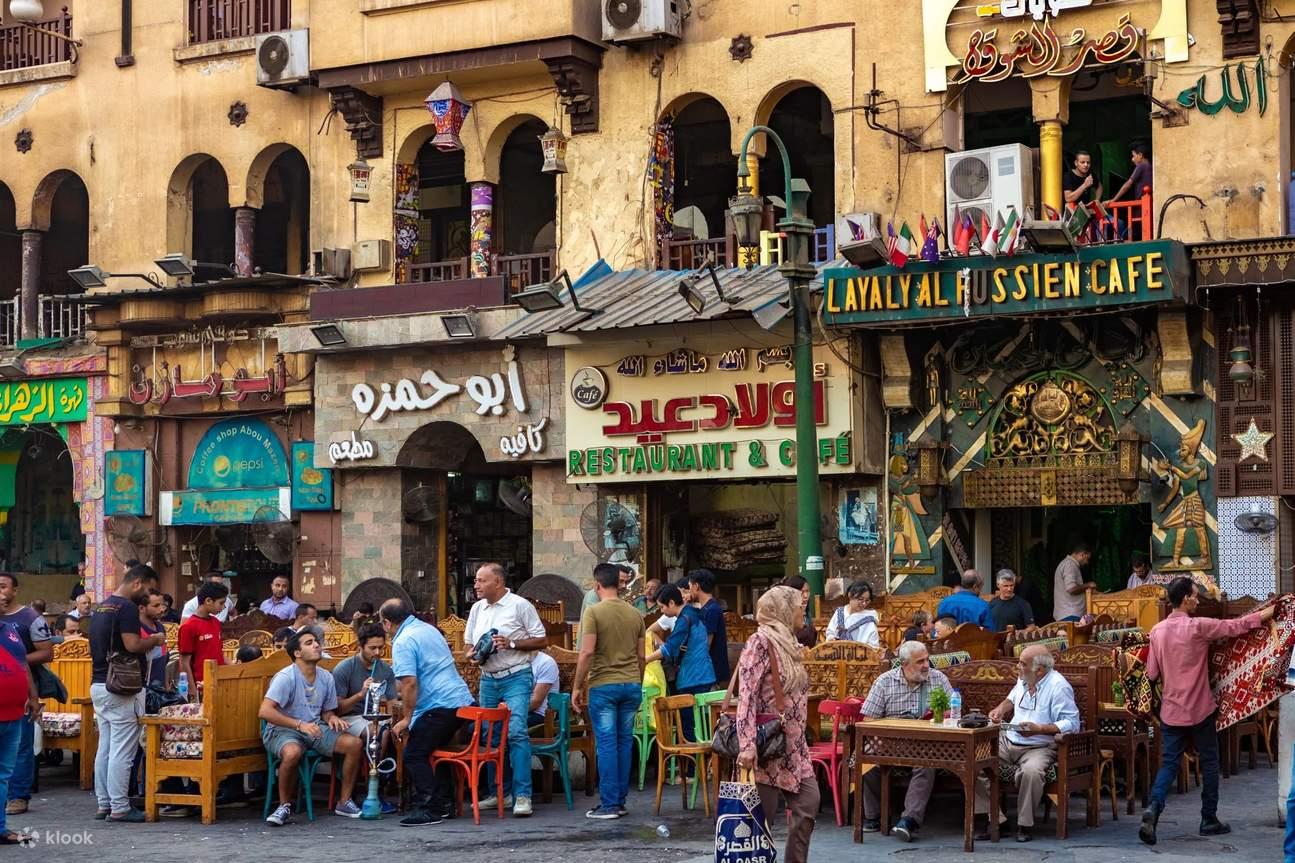Crowded outdoor cafes and restaurants lining a busy street in Khan el-Khalili bazaar