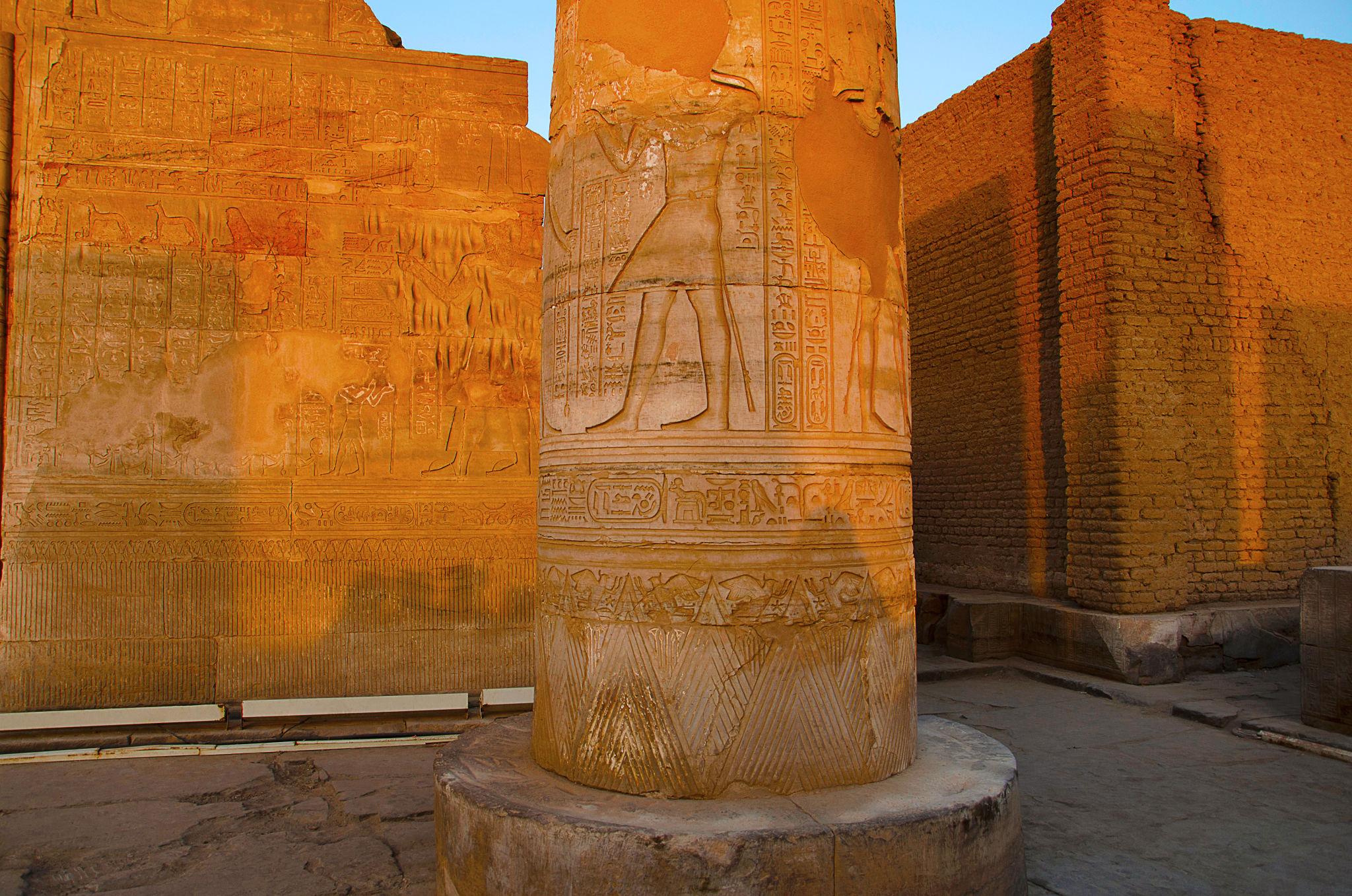 Carved temple column glowing in warm golden-hour light at Kom Ombo.