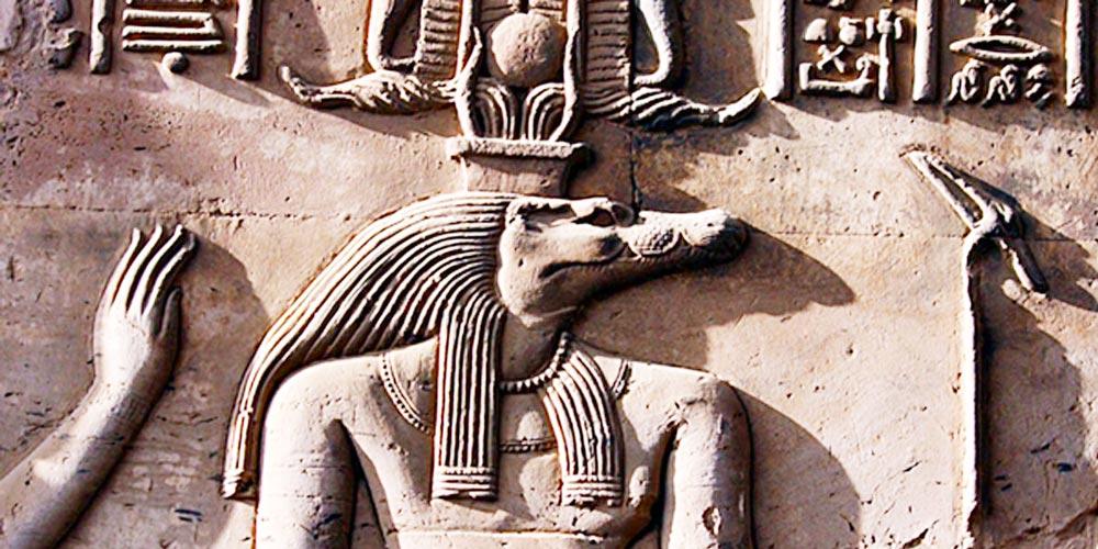 Detailed sandstone relief of Sobek, the crocodile-headed god, wearing an atef crown.