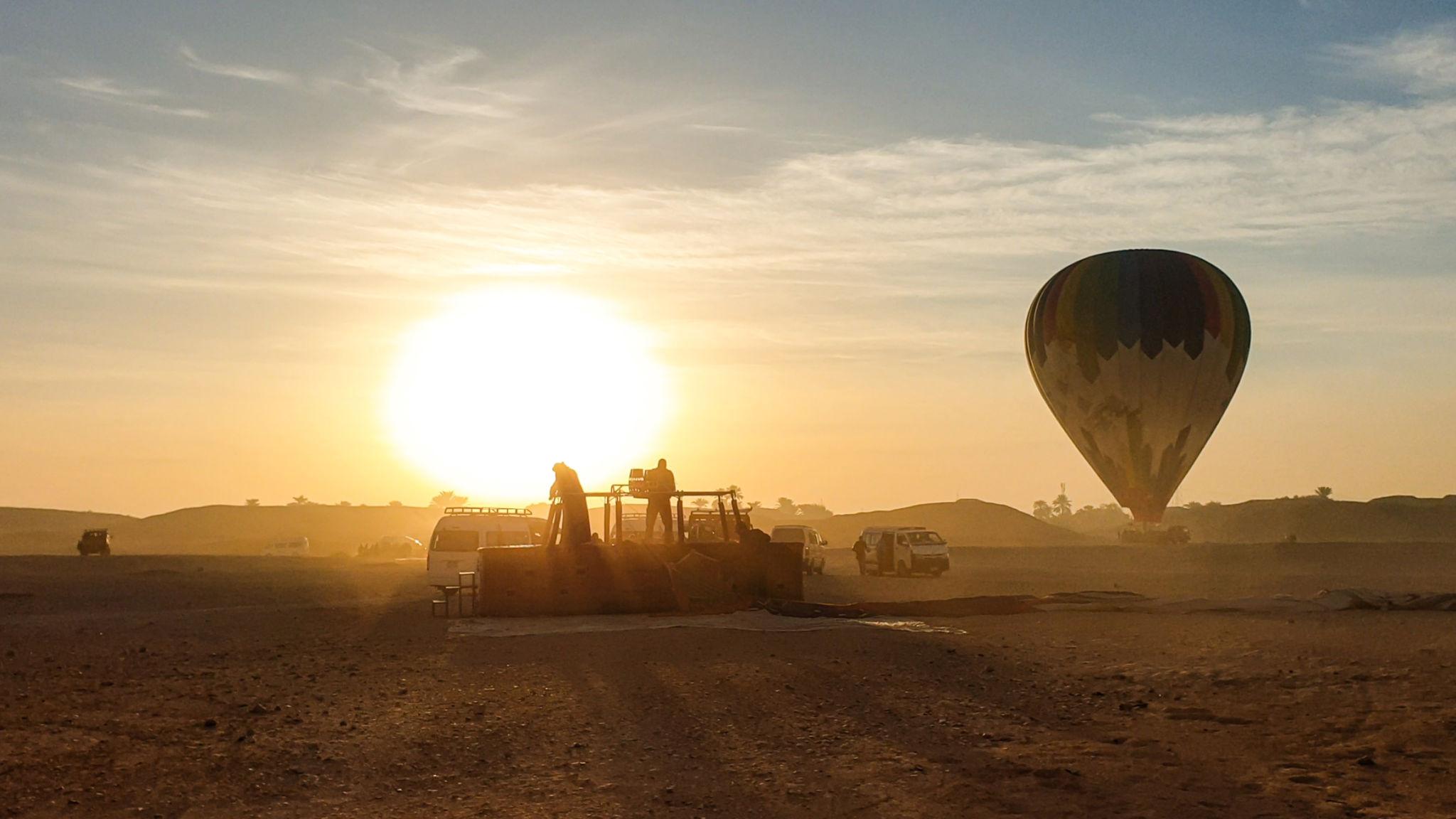 Balloon landed in the desert at sunrise with crew and support vehicle near Luxor