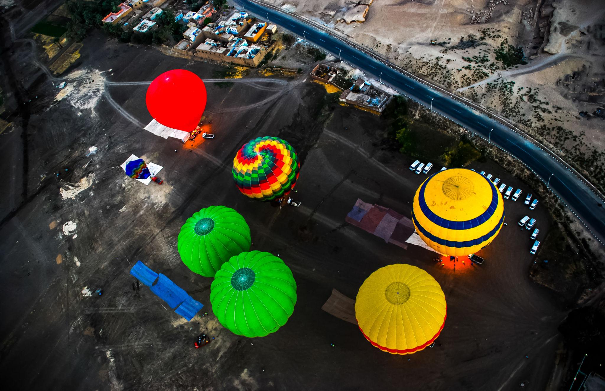 Overhead view of colorful balloons inflating at the Luxor launch site before sunrise