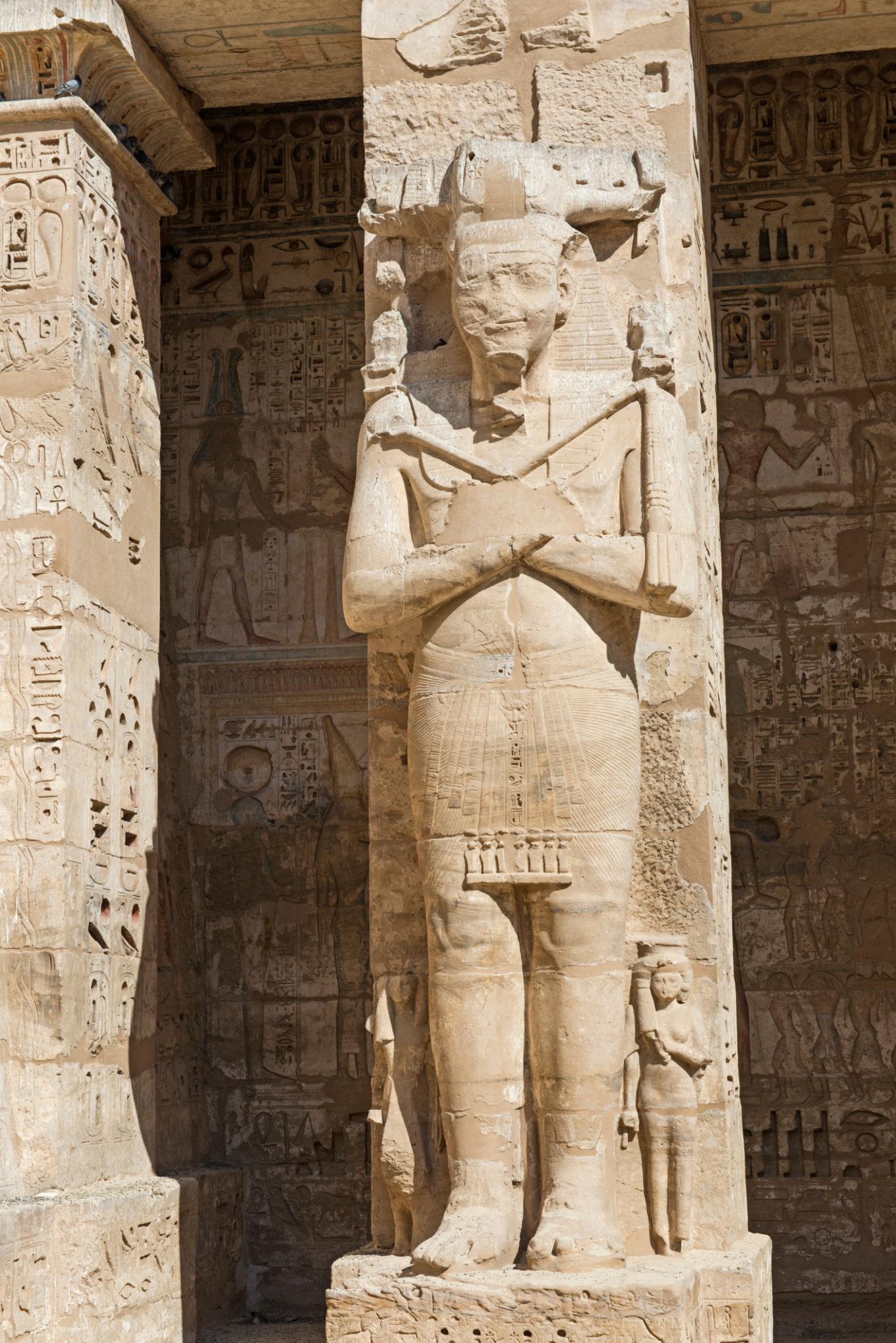 Osiride statue of Ramesses III standing between carved pillars at Medinet Habu.