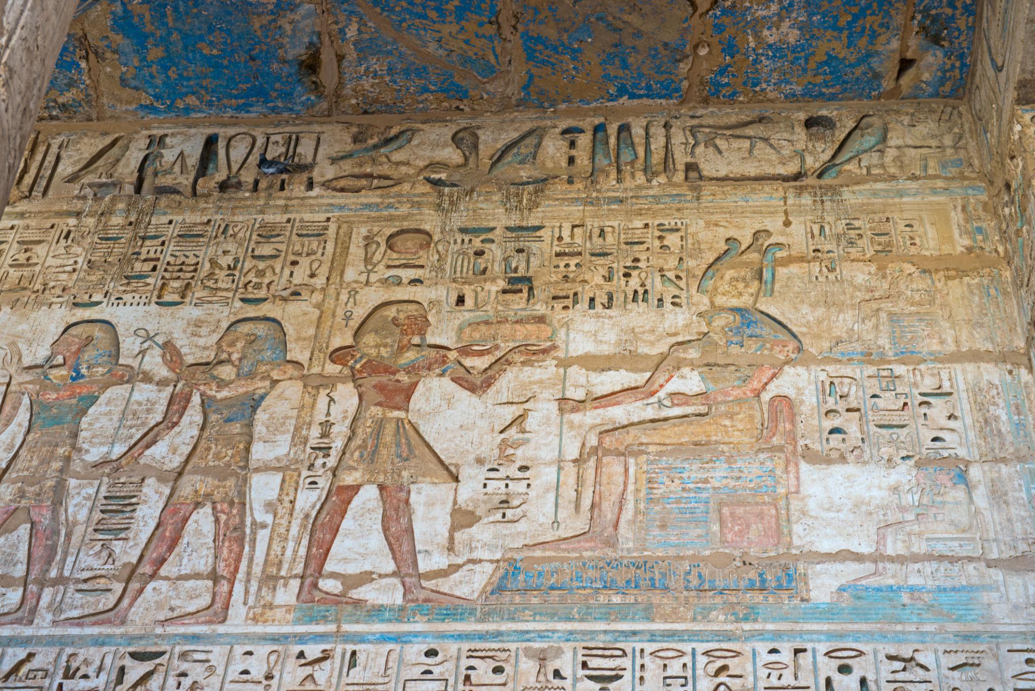 Painted relief of Ramesses III presenting offerings to an enthroned deity at Medinet Habu.