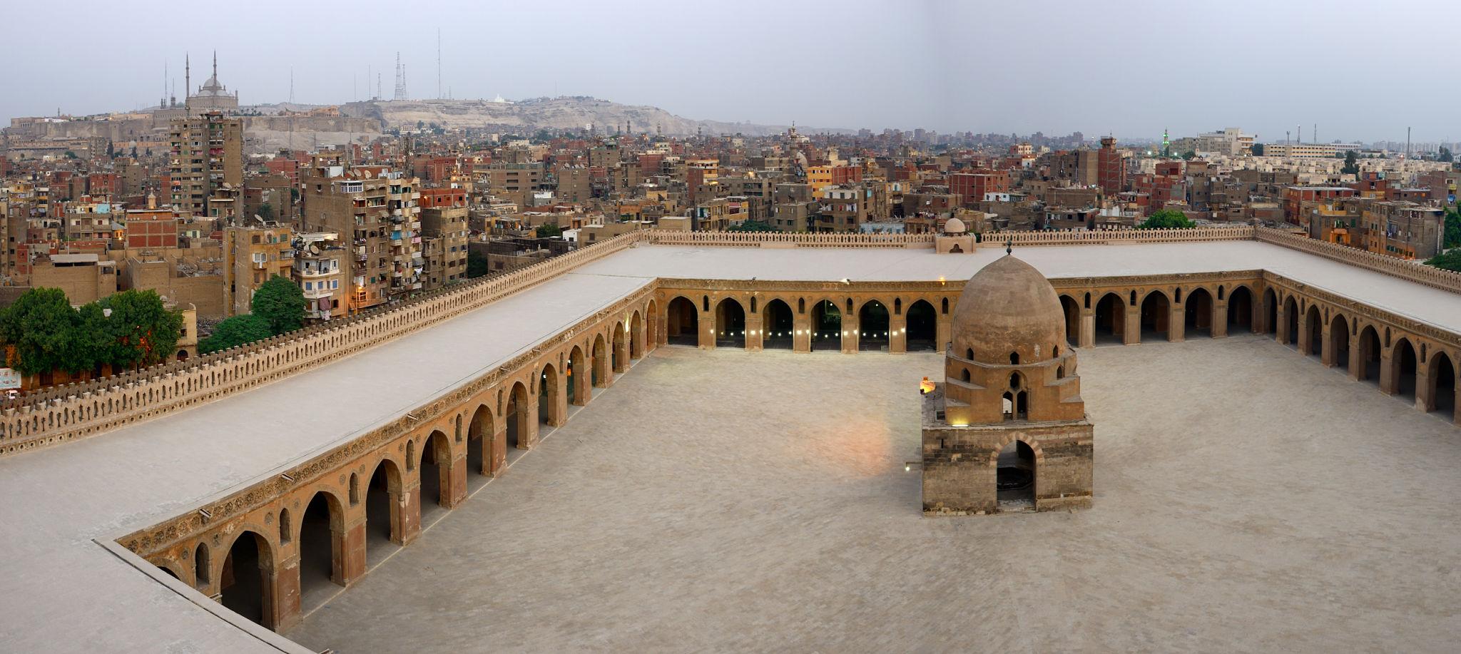 Aerial view of Ibn Tulun Mosque courtyard overlooking Cairo skyline and Citadel