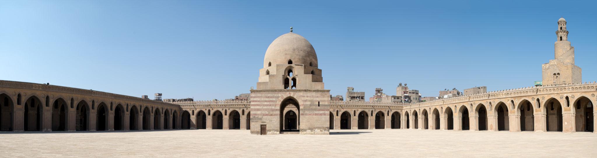 Wide panorama of Ibn Tulun Mosque courtyard with ablution dome and spiral minaret