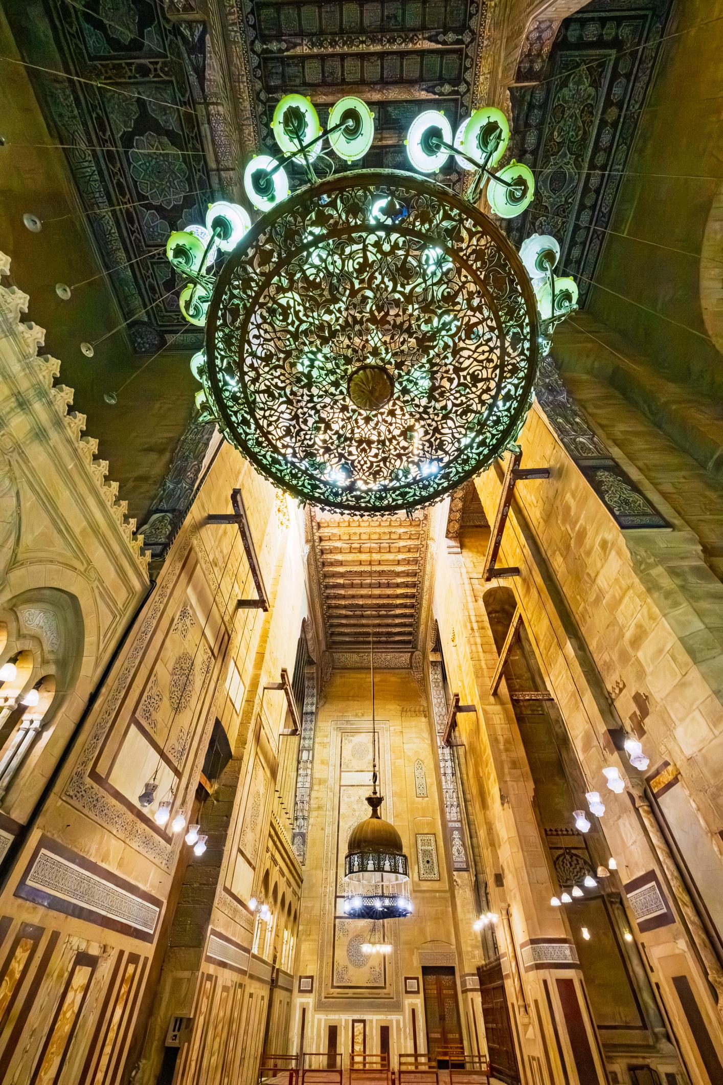 Ornate bronze openwork chandelier suspended in the lofty courtyard of Sultan Hassan