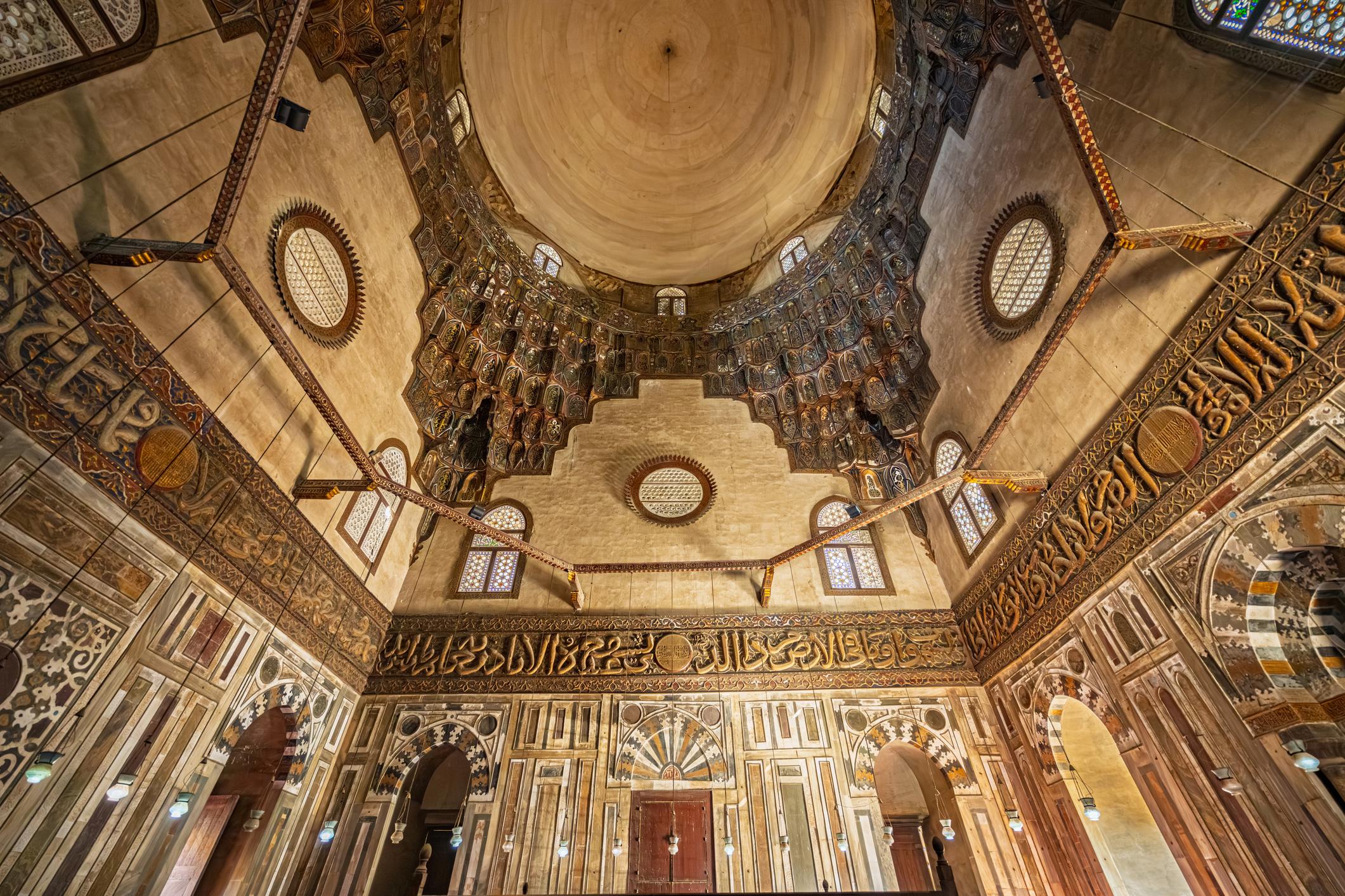Interior of the mausoleum dome with kufic frieze, oculus windows, and carved decoration