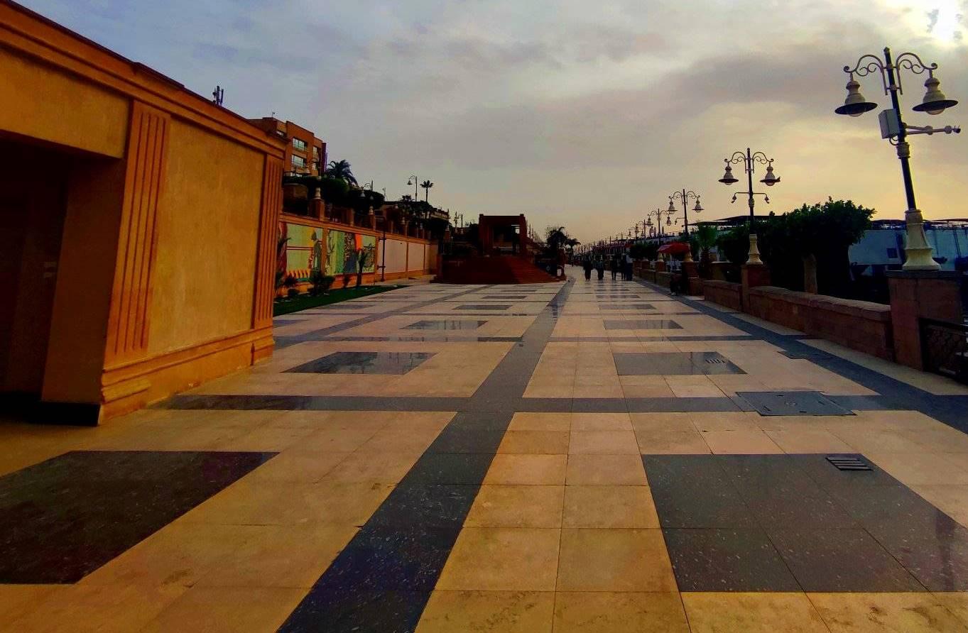 Geometric tiled promenade stretching along the Luxor Nile at dusk