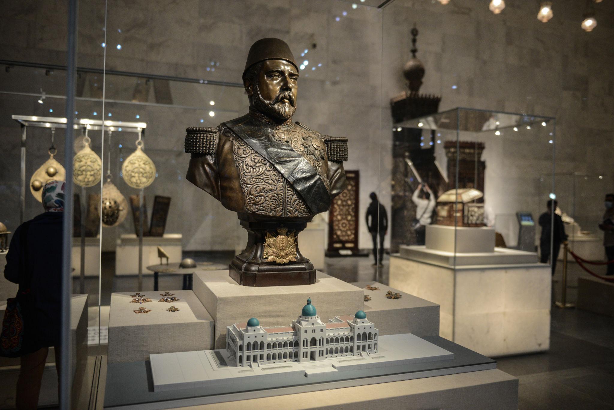 Bronze bust of a Ottoman-era ruler in military uniform displayed with medals and architectural model at NMEC