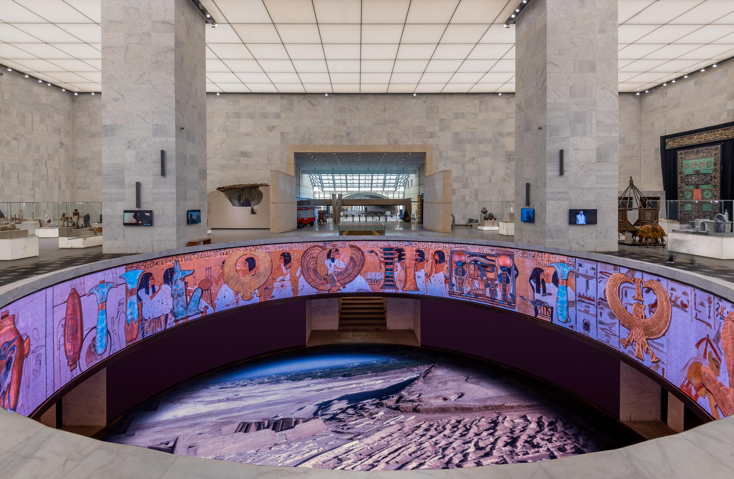 Immersive circular LED display showing ancient Egyptian murals and aerial pyramid views inside NMEC
