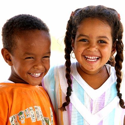 Two young Egyptian children smiling joyfully near the NMEC museum