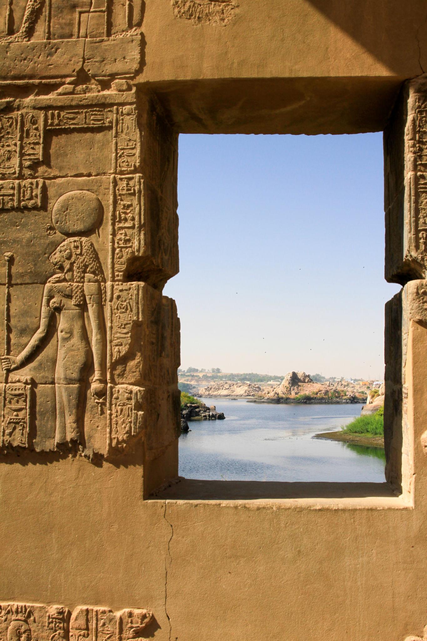 Ancient Egyptian goddess relief carved in stone with a window framing the Nile beyond